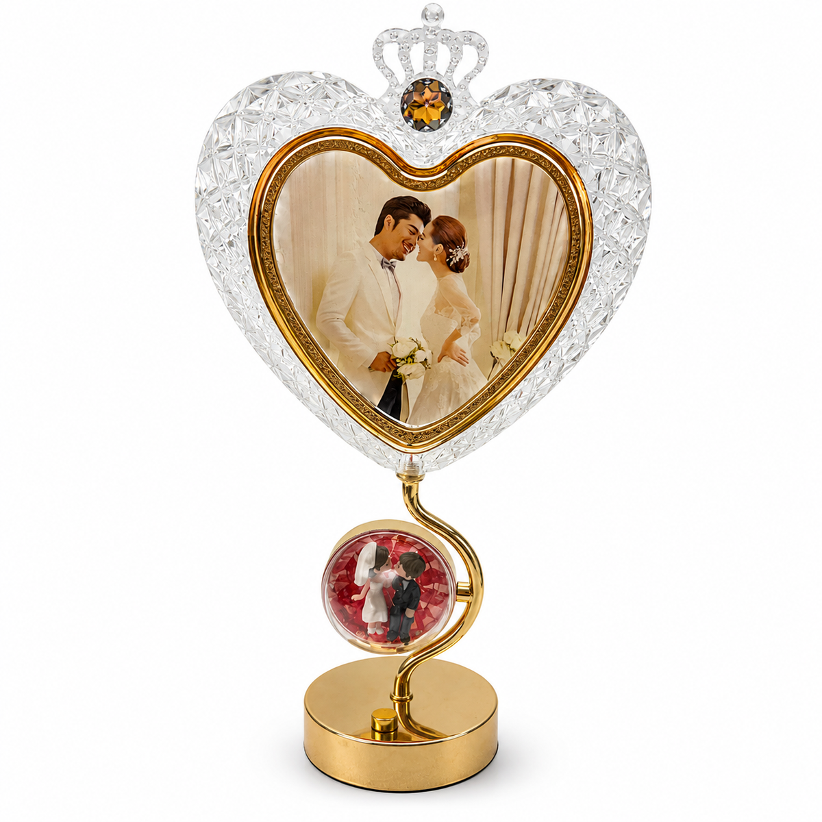 Crystal heart photo frame with crown and globe stand displayed on marble table with roses and candles
