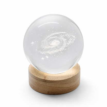 LED Crystal Ball galaxy night light glowing warm on bedside table
