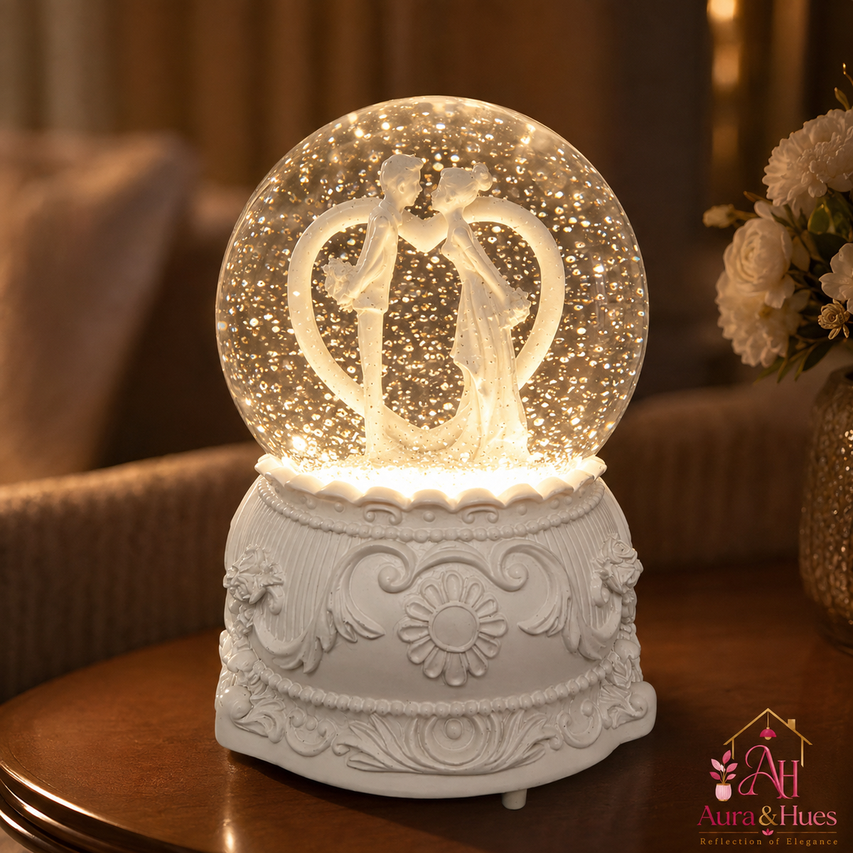 Aura & Hues wedding snow globe glowing on a table with floral backdrop